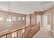Hallway features a chandelier, staircase, and windows allowing for natural light to brighten the space at 9740 Floweret Ave, Las Vegas, NV 89117