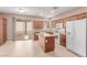 Bright kitchen featuring cherry cabinets, island with granite countertop, and stainless-steel appliances at 9740 Floweret Ave, Las Vegas, NV 89117