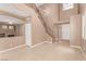 Open-concept living room with high ceilings, staircase, fireplace, and neutral tile flooring at 9740 Floweret Ave, Las Vegas, NV 89117
