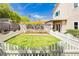 This backyard has a well-maintained lawn enclosed by a white picket fence at 977 Trackers Glen Ave, Henderson, NV 89015