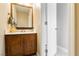 Cozy powder room with a wooden vanity, framed mirror, and neutral decor providing a functional and welcoming space at 977 Trackers Glen Ave, Henderson, NV 89015