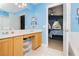 Bright bathroom with double sinks and wooden cabinetry, providing functional elegance, plus a view into the primary bedroom at 977 Trackers Glen Ave, Henderson, NV 89015