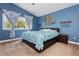Inviting blue bedroom featuring a well-lit window, comfortable bed, and decor that adds to its peaceful and relaxing atmosphere at 977 Trackers Glen Ave, Henderson, NV 89015