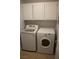 A practical laundry room equipped with a washing machine, a dryer, and convenient overhead storage cabinets at , Las Vegas, NV 89128