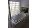 Elegant primary bathroom with a luxurious soaking tub, glass block window, and a fireplace for ultimate relaxation at , Las Vegas, NV 89128