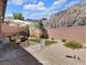 Desert landscaped backyard featuring a patio set, brick wall and small patch of green grass at 1063 Upper Springs St, Henderson, NV 89002
