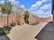 Enclosed backyard with desert landscape, minimal lawn, brick pavers, and a block wall against a rock formation at 1063 Upper Springs St, Henderson, NV 89002