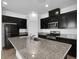 Stylish kitchen showcasing granite countertops, dark cabinets, and stainless steel appliances at 1063 Upper Springs St, Henderson, NV 89002