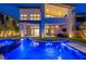 An alluring swimming pool with bar stools, waterfall, and hot tub next to a modern home at 10748 Steel Ridge Ct, Las Vegas, NV 89135