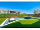A stunning swimming pool with a bar and hot tub surrounded by lush artificial grass at 10748 Steel Ridge Ct, Las Vegas, NV 89135