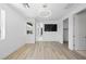 Open bedroom features light wood flooring, a modern light fixture, and doors to the ensuite bath and closet at 10748 Steel Ridge Ct, Las Vegas, NV 89135