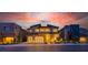 Stunning modern home featuring a three-car garage and beautiful sunset views at twilight at 10748 Steel Ridge Ct, Las Vegas, NV 89135