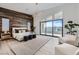 Large main bedroom with a wood accent wall and floor-to-ceiling windows at 10748 Steel Ridge Ct, Las Vegas, NV 89135
