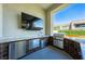 Outdoor kitchen with stainless steel appliances, marble countertops, and a large screen TV at 10748 Steel Ridge Ct, Las Vegas, NV 89135