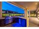 Outdoor kitchen with stainless steel appliances, marble countertops, and attractive lighting at 10748 Steel Ridge Ct, Las Vegas, NV 89135