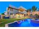Modern home featuring a shimmering pool, manicured lawn, patio with comfortable seating and a rock retaining wall at 1181 Calle De Luz, Henderson, NV 89012
