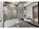Modern bathroom featuring gray tiling, sleek vanity with dark countertop, and a combined tub and shower at 1181 Calle De Luz, Henderson, NV 89012
