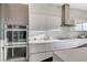 Modern kitchen featuring stainless steel appliances, sleek cabinetry, and marble backsplash at 1181 Calle De Luz, Henderson, NV 89012