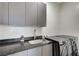 The modern laundry room is equipped with up-to-date machines and black sparkle countertops at 1181 Calle De Luz, Henderson, NV 89012