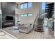 Living room features a black accent wall, fireplace, high ceilings, modern furnishings, and an open staircase at 1181 Calle De Luz, Henderson, NV 89012