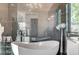 This luxurious main bathroom has a chandelier, gray cabinets, and stand alone modern bath tub at 1181 Calle De Luz, Henderson, NV 89012