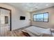 Bright primary bedroom featuring a TV, a large window, and hardwood flooring at 1181 Calle De Luz, Henderson, NV 89012