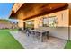 Charming outdoor patio featuring a dining area and lush green lawn for perfect outdoor gatherings and relaxation at 1181 Calle De Luz, Henderson, NV 89012