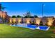 Backyard features a luxurious pool and spa, surrounded by neatly trimmed artificial turf and ambient lighting at 1181 Calle De Luz, Henderson, NV 89012