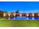 Backyard pool and spa are illuminated, surrounded by manicured greenery and a privacy wall with soft lighting at 1181 Calle De Luz, Henderson, NV 89012