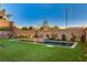 Modern backyard features an inviting pool and spa, complemented by a lush green lawn and landscaped perimeter at 1181 Calle De Luz, Henderson, NV 89012
