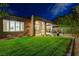 Backyard featuring a lush lawn, desert landscaping, and a covered patio area at 12 Kennesaw Rd, Henderson, NV 89052