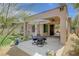 Landscaped backyard boasts a covered patio with dining furniture, desert plants, and lush grass at 12 Kennesaw Rd, Henderson, NV 89052