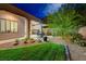 Backyard with lush grass, desert landscaping and an outdoor patio with grill and dining table at 12 Kennesaw Rd, Henderson, NV 89052