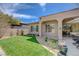Backyard featuring green lawn, patio area, desert landscaping, and partial shade for outdoor enjoyment at 12 Kennesaw Rd, Henderson, NV 89052