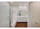 Bright bathroom with a tub, glass enclosed shower, white vanity with double sinks, and dark wood floors at 12 Kennesaw Rd, Henderson, NV 89052
