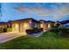 Charming single-story home with a two-car garage and a well-manicured lawn at twilight at 12 Kennesaw Rd, Henderson, NV 89052