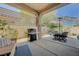 Inviting covered patio featuring outdoor seating, barbecue grill, and desert landscaping at 12 Kennesaw Rd, Henderson, NV 89052