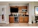 A kitchenette with wooden cabinets, a mini-fridge, a sink, a microwave and a wall mounted TV at 145 E Harmon Ave # 3807, Las Vegas, NV 89109