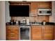 A kitchenette with wooden cabinets, a mini-fridge, a sink, a microwave and a wall mounted TV at 145 E Harmon Ave # 3807, Las Vegas, NV 89109