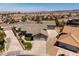 Aerial view of a home with a pool, desert landscaping, tile roof, and a three-car garage at 190 Channel Dr, Henderson, NV 89002