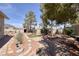 Lush backyard with mature trees, decorative stonework, a firepit area, and well-maintained desert landscaping at 190 Channel Dr, Henderson, NV 89002