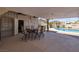 Relaxing covered patio with ceiling fans, an outdoor dining set, and views of the sparkling pool at 190 Channel Dr, Henderson, NV 89002