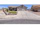 Charming home exterior with desert landscaping, a well-kept lawn, and a large driveway with two-car garage at 190 Channel Dr, Henderson, NV 89002