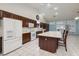 Open kitchen features tile floors, an island with seating, and dark wood cabinets at 190 Channel Dr, Henderson, NV 89002