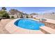 Backyard swimming pool surrounded by mature landscaping, with a patio and benches at 190 Channel Dr, Henderson, NV 89002