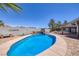 Sparkling pool with rock wall, built-in bench, and brick-paved patio area at 190 Channel Dr, Henderson, NV 89002