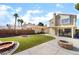 Inviting backyard with lush lawn, brick-lined fire pits, and covered patio perfect for outdoor entertaining at 2046 Waverly Cir, Henderson, NV 89014