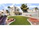 Backyard featuring synthetic grass, rock accents, brick firepits, and a privacy wall at 2046 Waverly Cir, Henderson, NV 89014