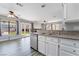 Contemporary kitchen with stainless steel dishwasher, bright white cabinets, and a seamless view into the living room at 2046 Waverly Cir, Henderson, NV 89014