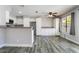 Well-lit kitchen features white cabinets, stainless appliances, bar seating, and wood-look tile floors, perfect for gatherings at 2046 Waverly Cir, Henderson, NV 89014